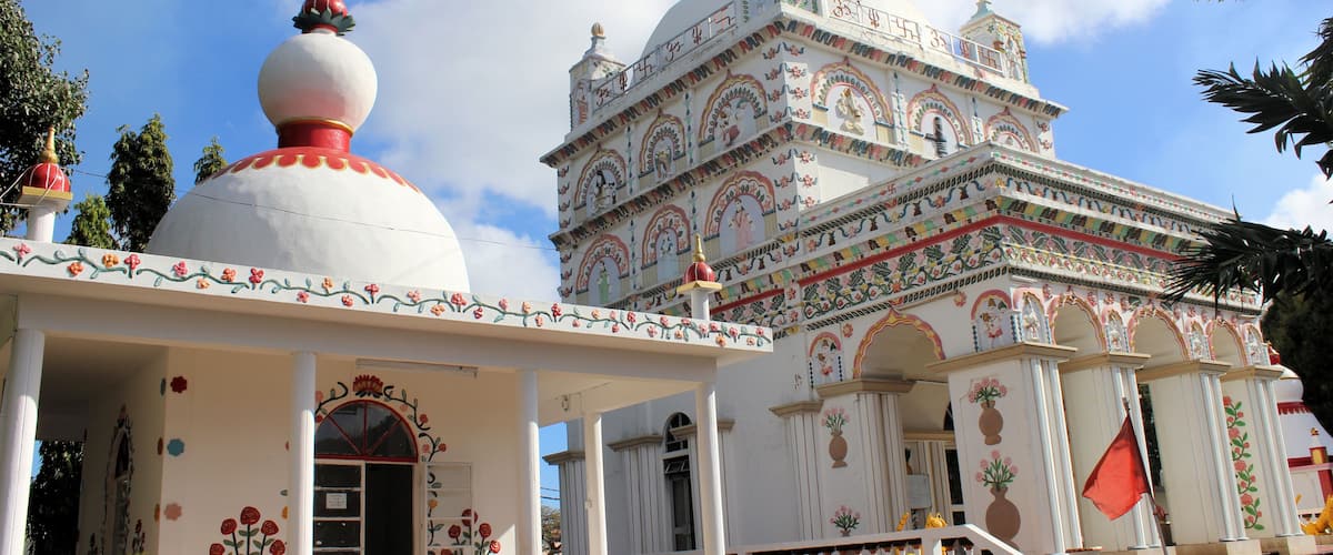 A white temple with colorful decorations and a large dome.