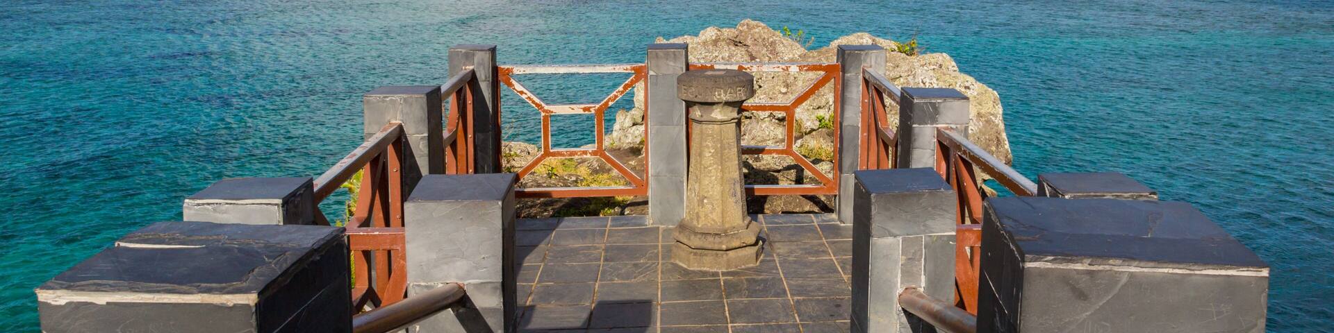 A stone staircase leading to a coastal overlook with a view of the ocean and a clear sky.