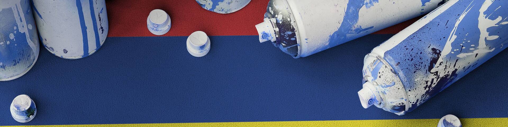 Mauritius flag and few used aerosol spray cans for graffiti painting. Street art culture concept, vandalism problems