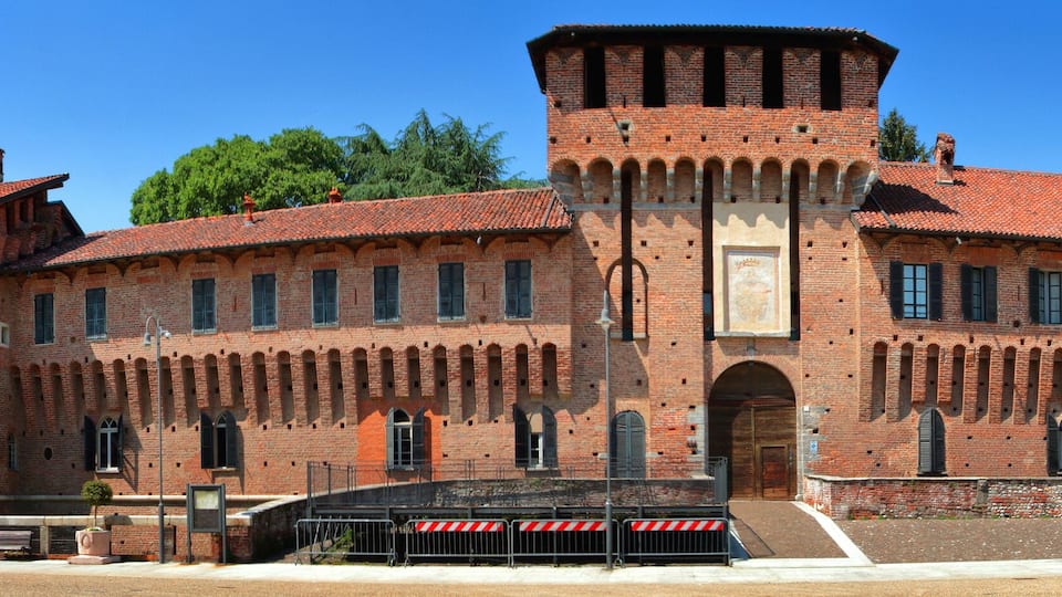 A large brick building with arched windows and a tower.