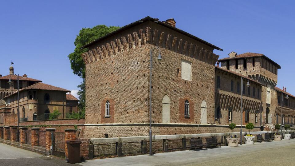 A historic brick building with arched windows and a tower.