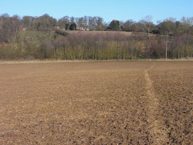 Farmland, Beenham A footpath is seen crossing an arable field as it descends into the valley of The Bourne, a minor tributary of the River Pang. Beyond the right of way climbs through pasture to Gunnells Farmhouse.