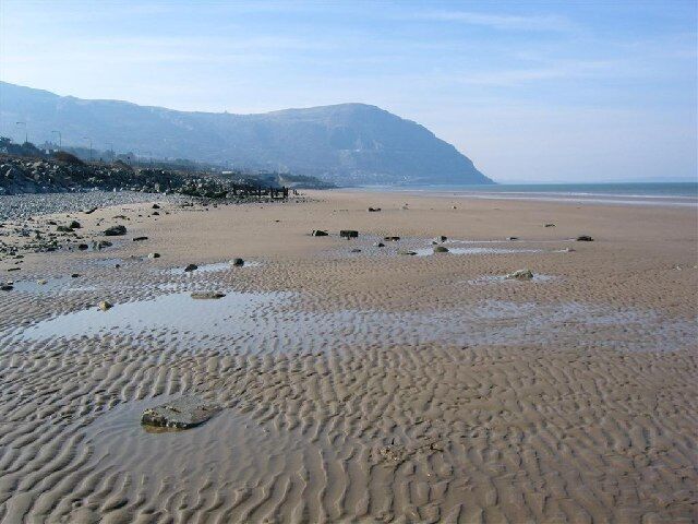Penmaenmawr Sands. Most of this sector is sea and sand, with a stretch of the A55 and railway on its southern edge. This photo faces south-west with Penmaenmawr mountain in the distance.