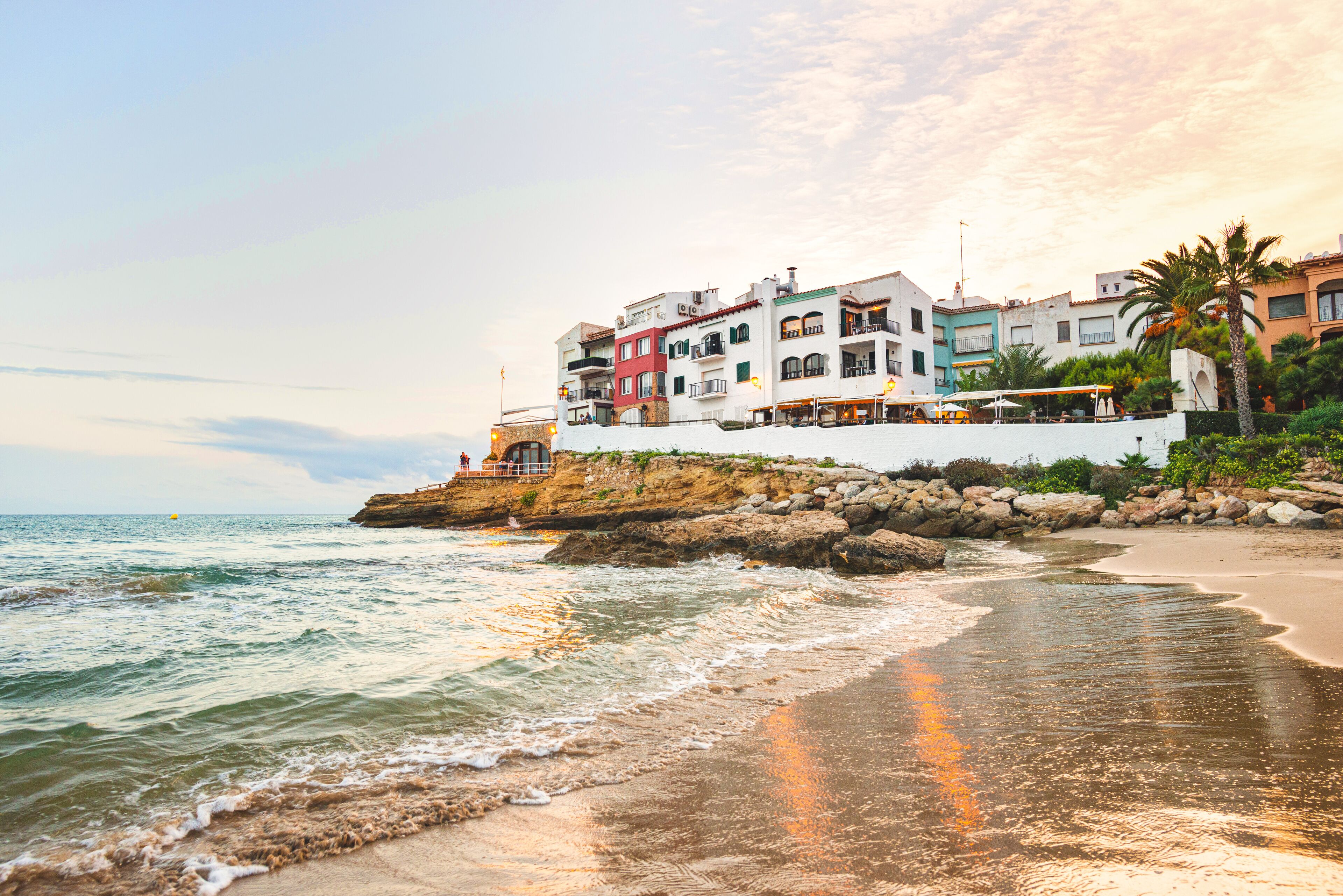 Beautiful white houses, mediterranean sea and a clear blue sky in the setting sun and sunset in El Roc de Sant Gaieta, Catalonia