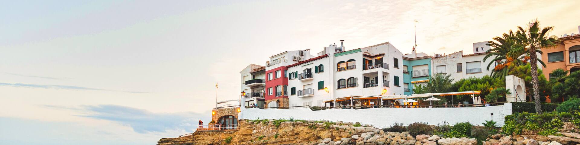 Beautiful white houses, mediterranean sea and a clear blue sky in the setting sun and sunset in El Roc de Sant Gaieta, Catalonia