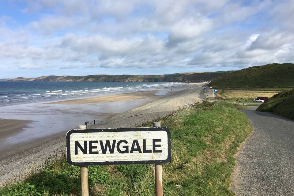 A beach with a sign reading "NEWGALE".