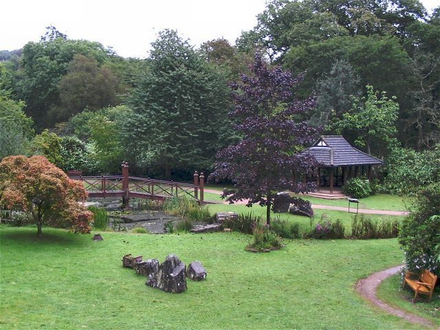A park with a gazebo, a bridge, and a pond.