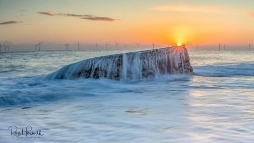 An old pill box at Caister on Sea Norfolk taken on a high tide at Sunrise