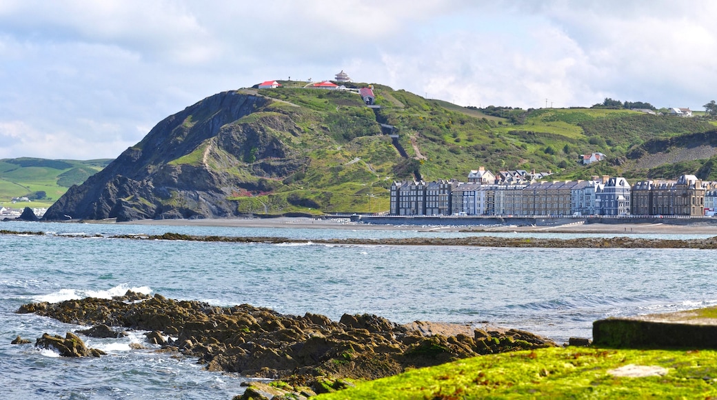A coastal town with a prominent hill, a pier, and a row of colorful buildings.