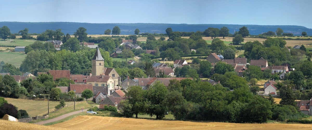 A rural village with a church, houses, and fields.