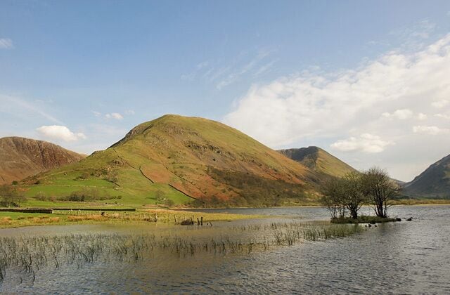 A lake with a small island and hills in the background.