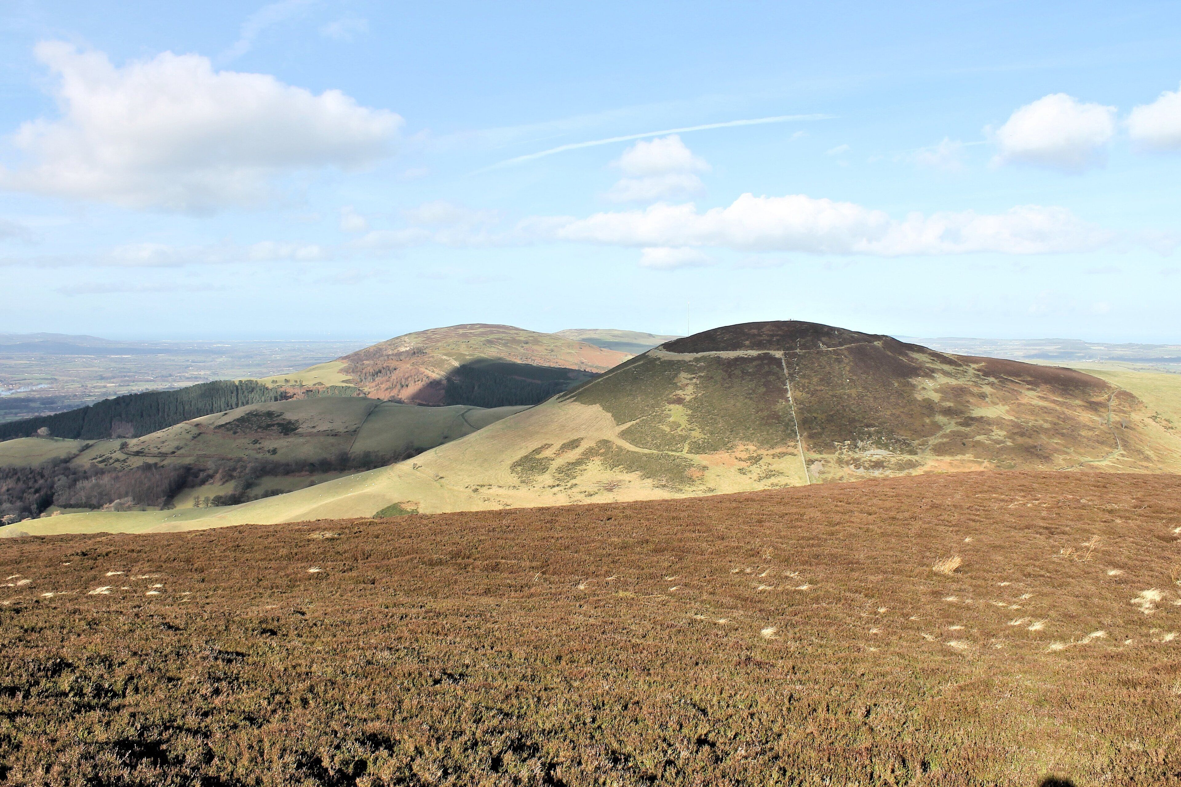 A hilly landscape with a clear sky and distant views of a valley.