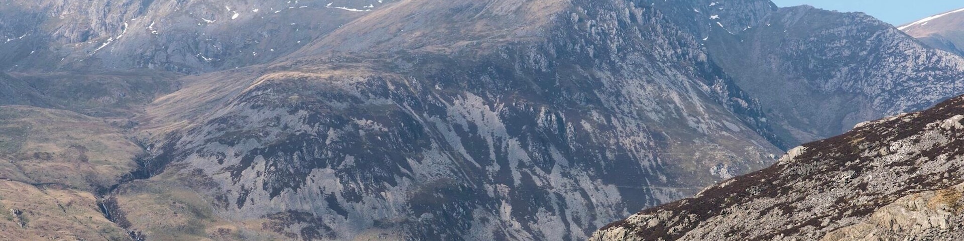 Un paysage montagneux avec un lac au premier plan et un sommet imposant en arrière-plan.