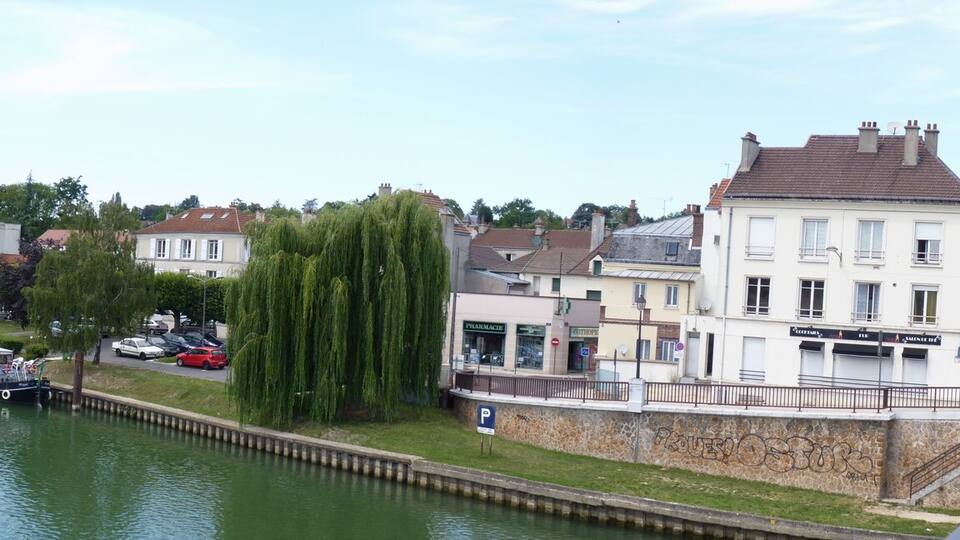 A river with boats, a bridge, and buildings along the banks.