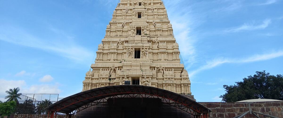 A tall, intricately carved temple tower with a pointed top and multiple statues.