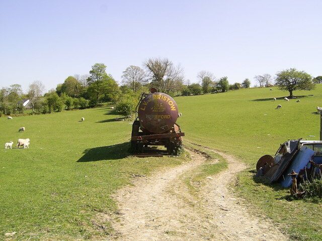 Disused trailer near Silian This sloping field lying to the west of the village of Silian contains an assortment of rusting cars, vans, farm machinery and other scrap.