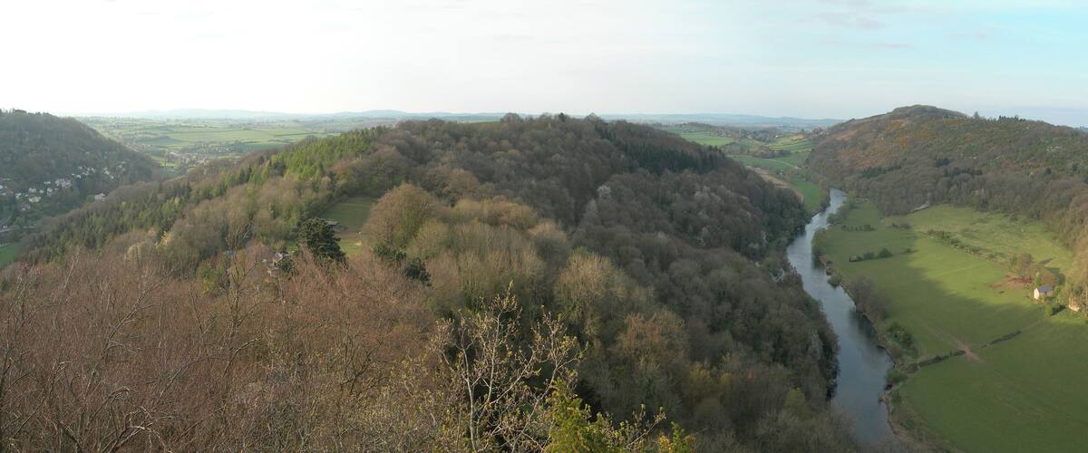 A river winding through a valley with hills on either side.