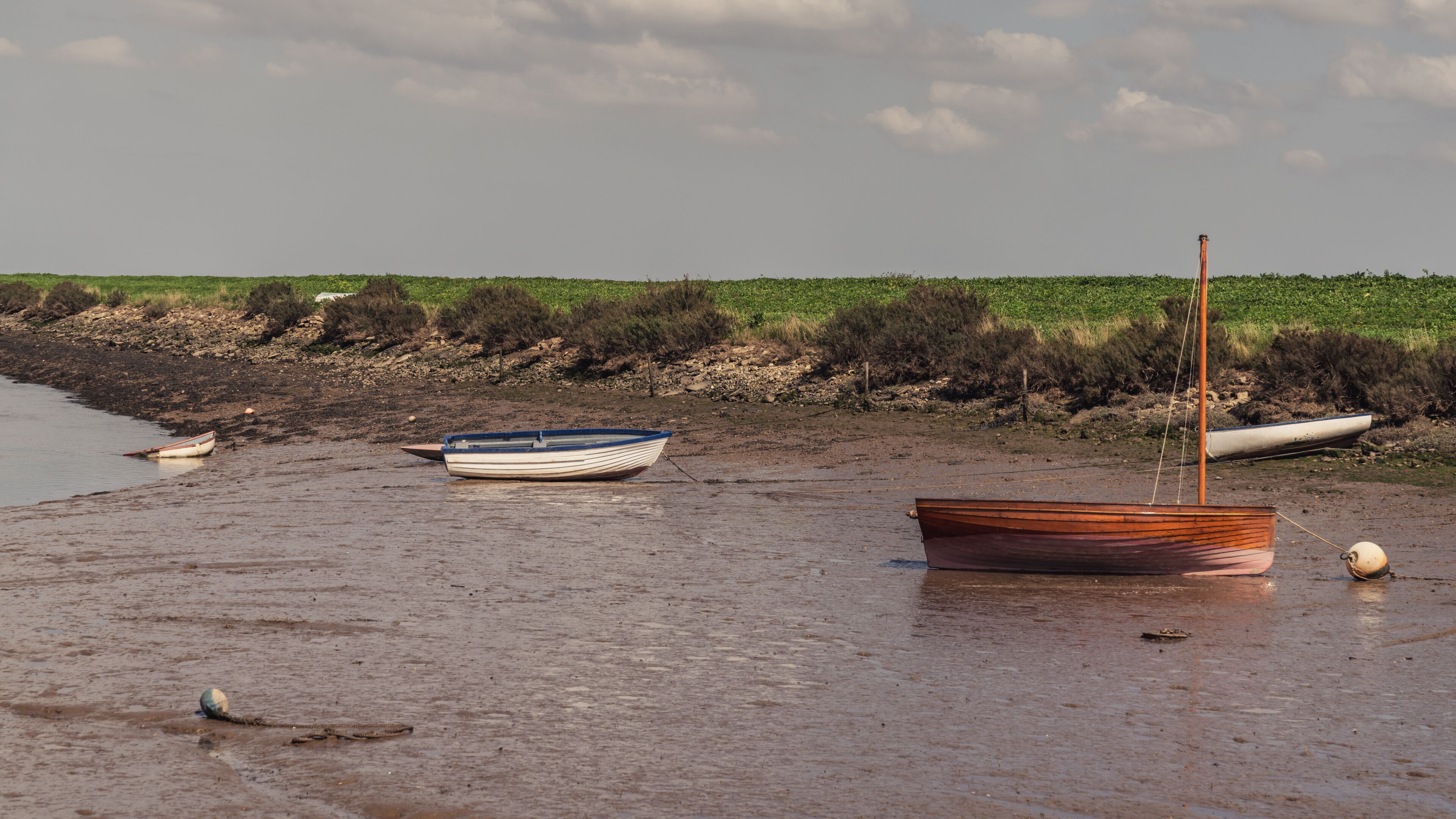 Boats in the Overy Marshes, seen in Burnham Overy Staithe, Norfolk, England, UK