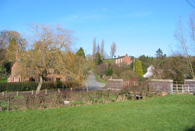 Higher Wych The small village of Higher Wych lies beside Wych Brook (foreground). The bridge over the lane running N-S through the village can be seen on the right. The village is backed by a low ridge (left)
