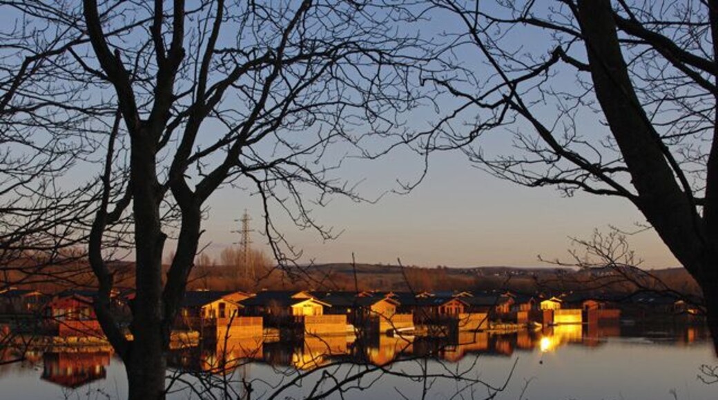 Lakeland Leisure Village The prefix "South" appears to have been dropped, possibly because it is not in South Lakeland District. The original name of the farm here was Dock Acres. The chalets are reflected in a flooded gravel pit at sunset.