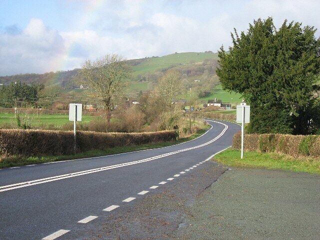 The A458 At the junction with the B4395 between Llangadfan and Foel. A partial rainbow rises from the left of the photograph.