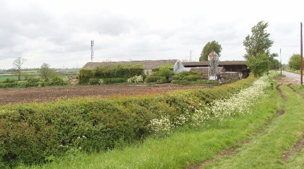 North Hill Farm The farm buildings are on the A413 main road. View from its junction with the minor road to Granborough. The field over the hedge has been ploughed recently.