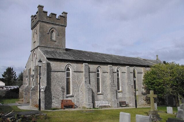 A stone church with a bell tower and arched windows.