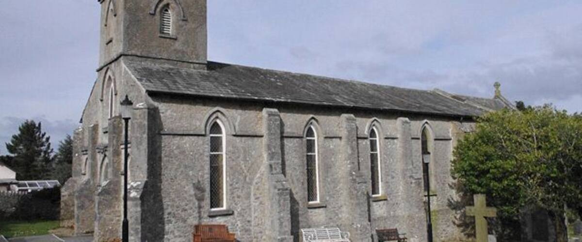 A stone church with a bell tower and arched windows.