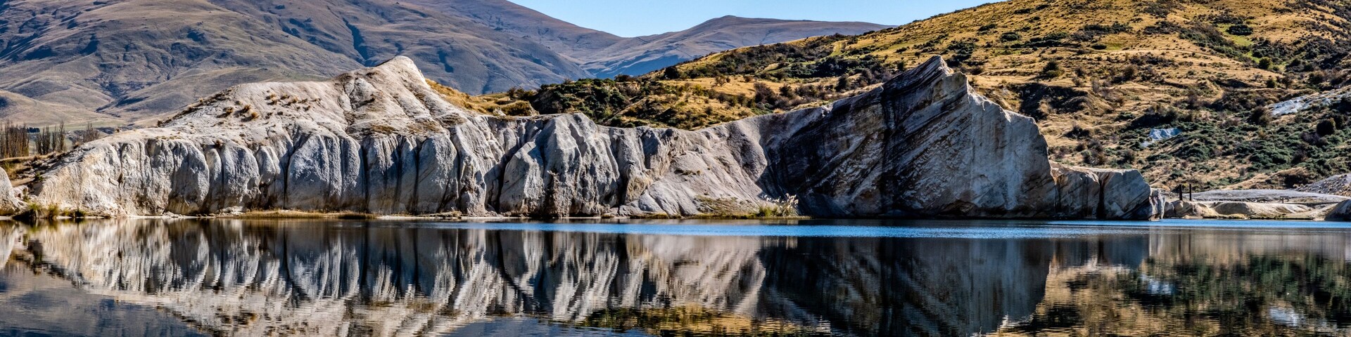 Una cordillera con un lago que refleja su silueta.