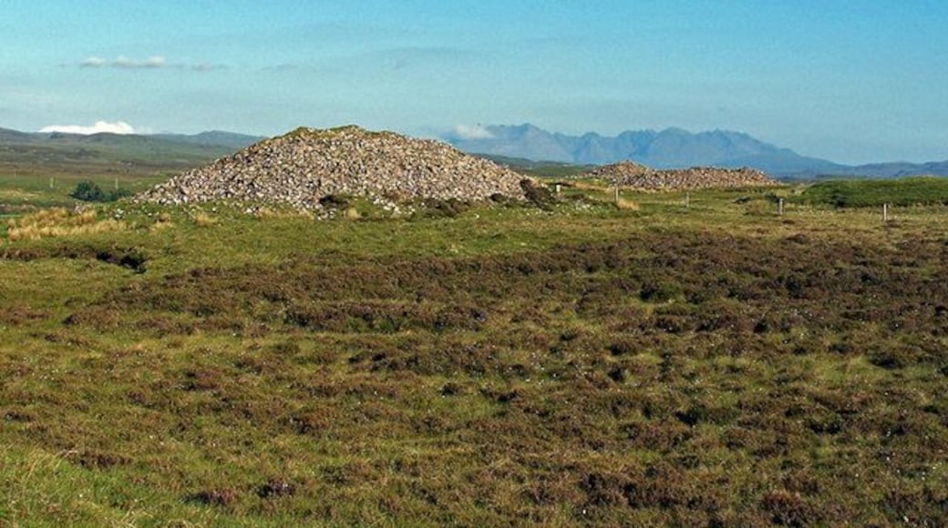 Barpannan chambered cairns To most passers by, these are just large piles of stones. However, they are Neolithic chambered cairns, and have been here for at least four thousand years. The Highland Environmental Record provides the following information: "A prominent, probably chambered cairn about 20' high and 90' in diameter, of relatively small, rounded boulders, partly turf-covered. There has been some robbing and disturbance, especially on the SW side near the top, but this appears to be quite superficial. The sides are steep, but the angle becomes more gentle near the edges giving the cairn a slightly bell-shaped profile. At the very edge of the cairn there is a kerb of stones, set either flat or on their long edges. The kerb-stones appear to have been contiguous originally, and remain so on the NE segment. Kerb-stones at short intervals can be traced round most of the east half and occasionally round the rest of the cairn. The stones seem to have varied considerably in size; the largest is 3' 2" high and about 6' long and others are 4' long, but some are relatively small. The profile of the cairn and the fact that the cairn material does not appear to have fallen outside the kerb suggests that the kerb originally edged a platform extending beyond the actual edge of the cairn. Another cairn showing some constructional similarities and probably chambered lies to the south (NG24SE 12). RCAHMS 1928; Information from MS of A S Henshall's 'Chambered Tombs of Scotland' Vol. 2, visited 24 October 1962." Highland Environmental Record website - http://her.highland.gov.uk/SingleResult.aspx?uid=MHG4849 .