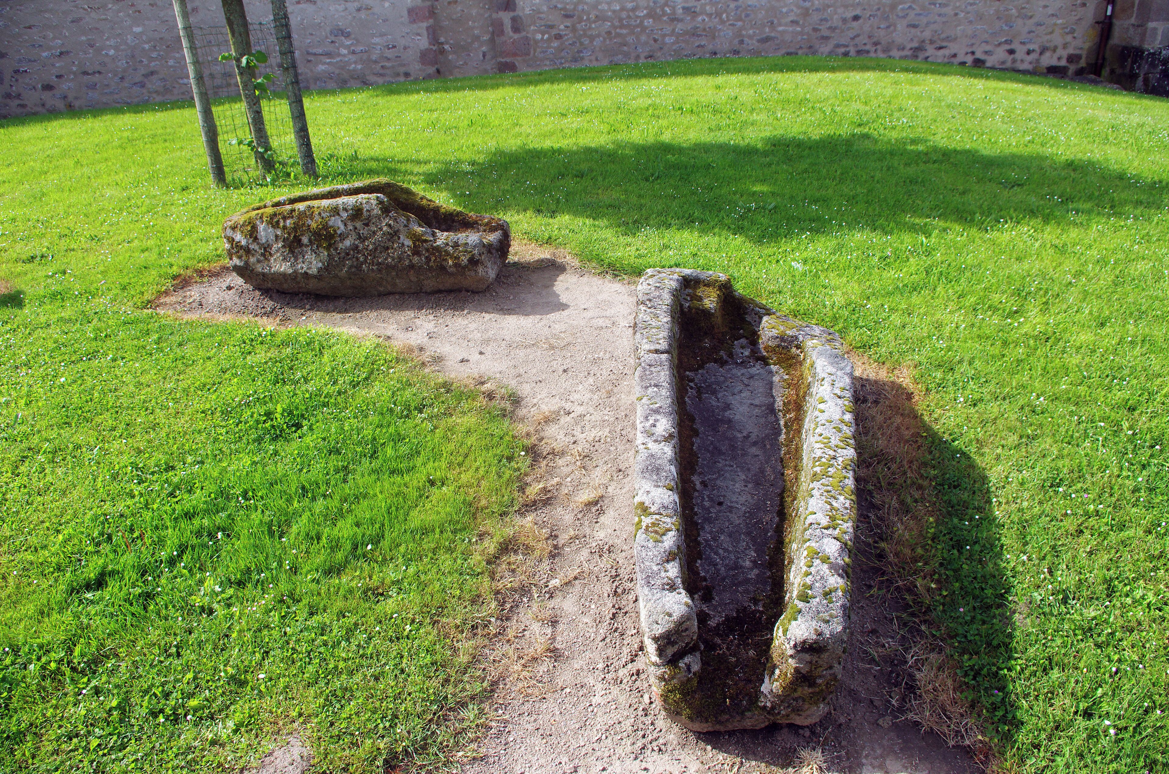 Crozant (Creuse). Esplanade "Chaupline".(Esplanade de l'église). Avant 1918 le cimetière  était attenant à l'église. Des sarcophages en granit encore visibles attestent de son existence.
 Ces sarcophages de granit, avec emplacement de la tête (forme céphalique), datant du Xème siècle, ont été mis à jour lors de l'érection du monument aux morts, près de l'église.