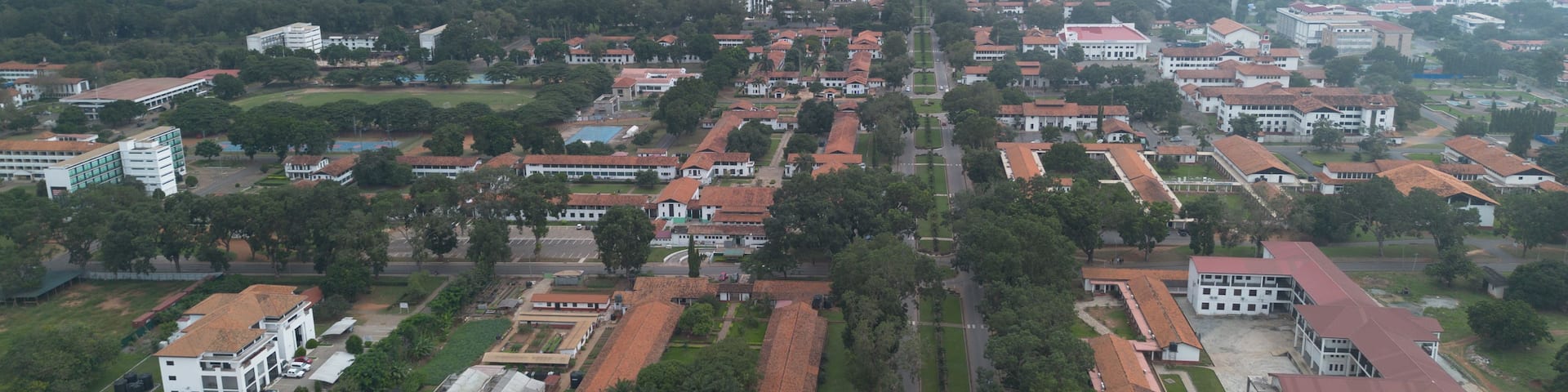 An aerial view of a city with a prominent hilltop structure, dense residential areas, and surrounding greenery.