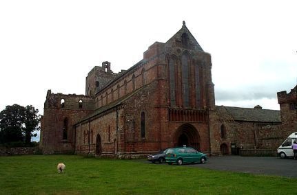 Uma igreja histórica de tijolos com uma grande entrada em arco e um campanário.