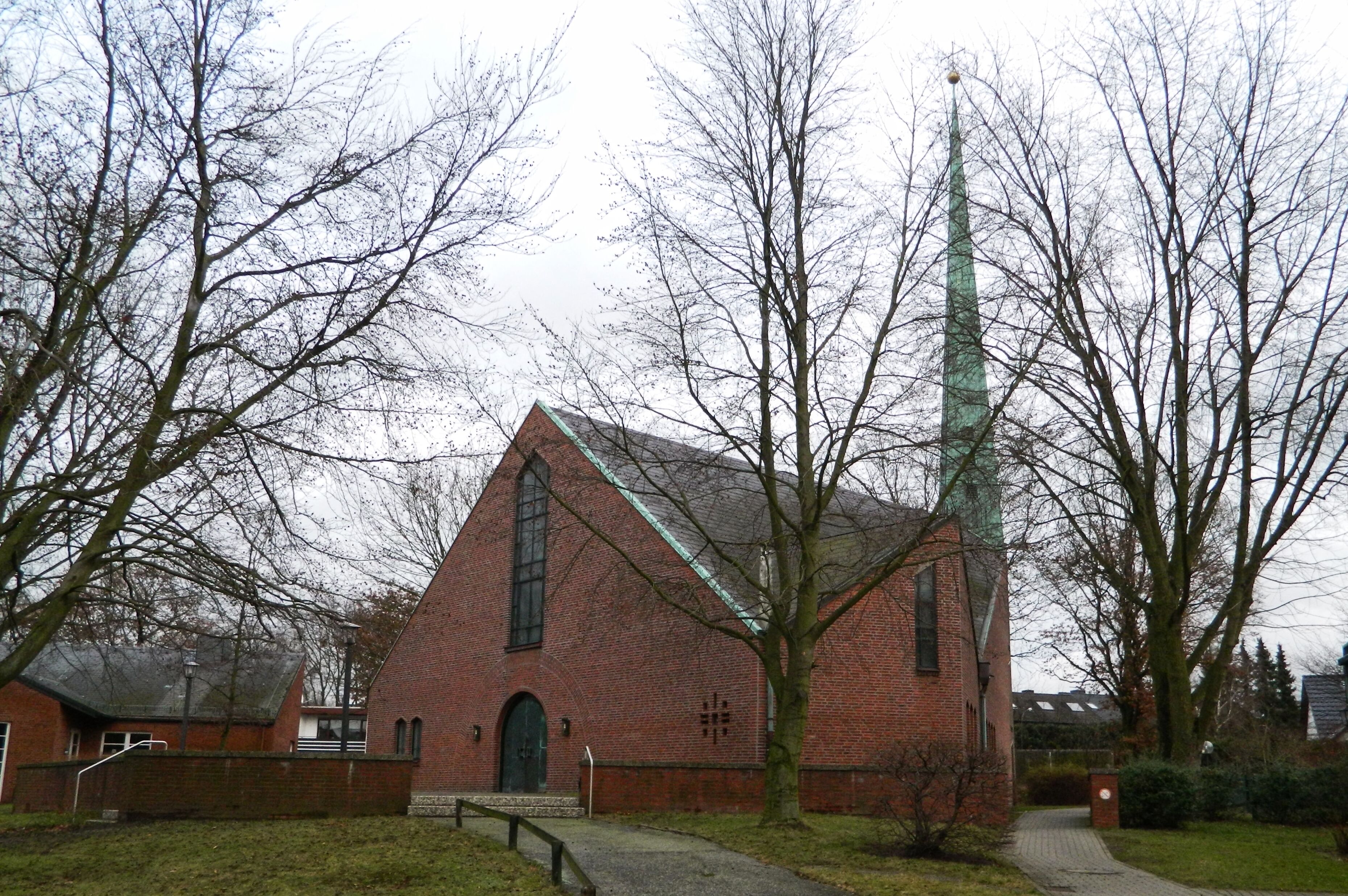 A brick church with a tall steeple and a large window.