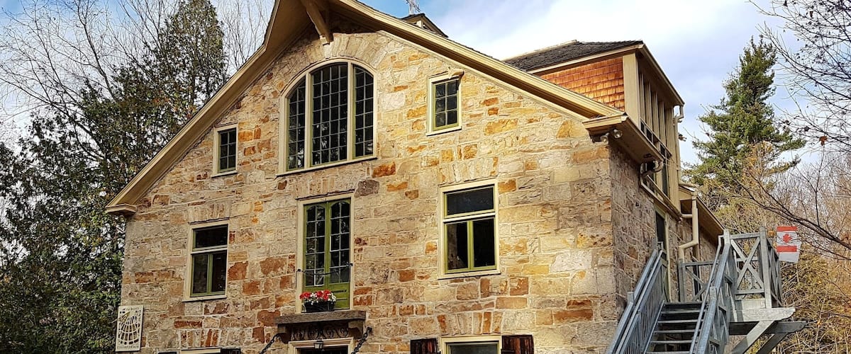 A stone building with a wooden staircase and a small garden.