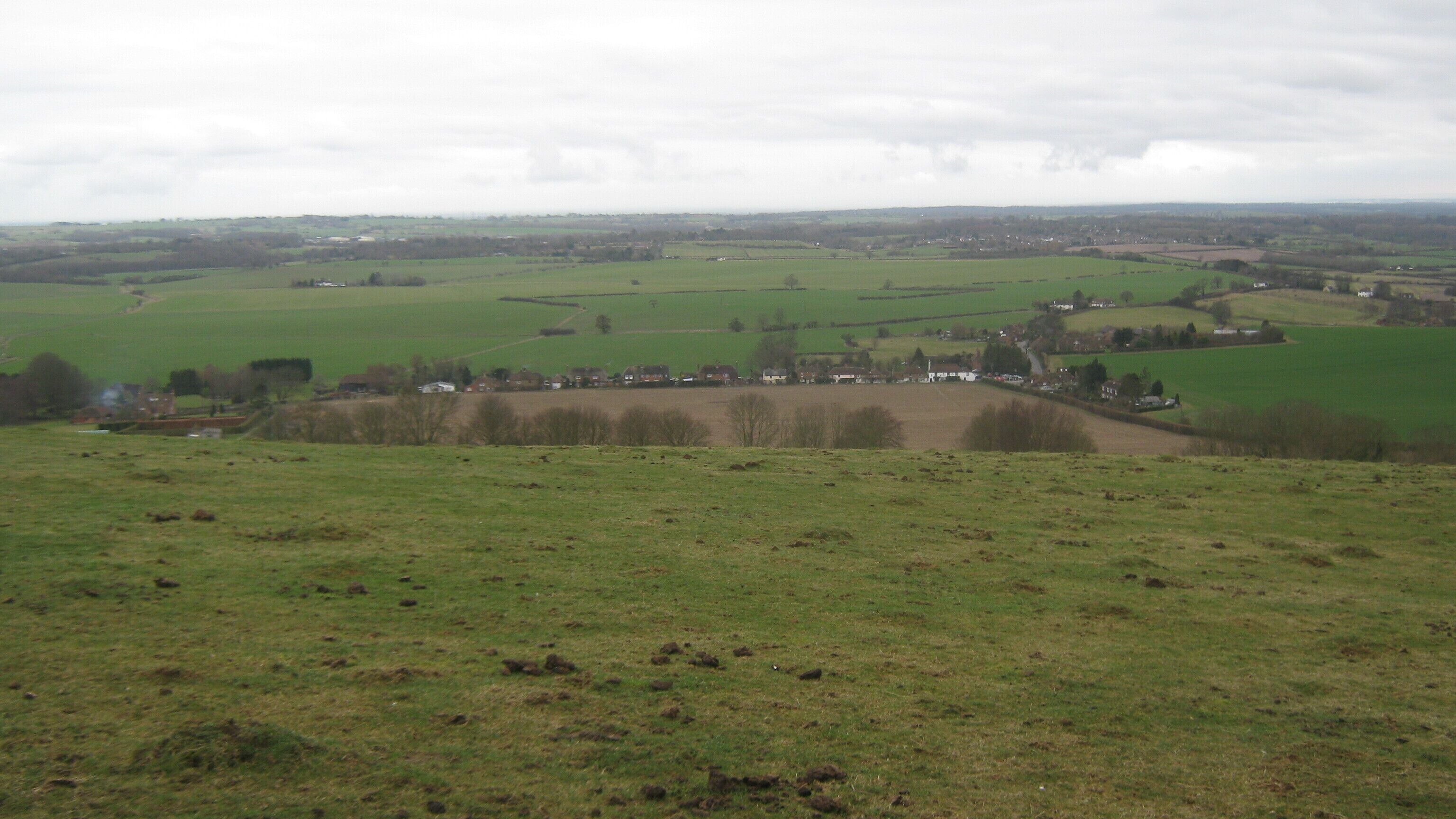 View of Brabourne from the North Downs Way The long distance path heads on a byway towards Brabourne Downs. Brabourne is a good example of a 'ribbon development' village. See Ribbon_development for more details.