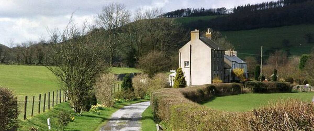 A rural path leading to a house with a 'PRIVATE ROAD' sign.