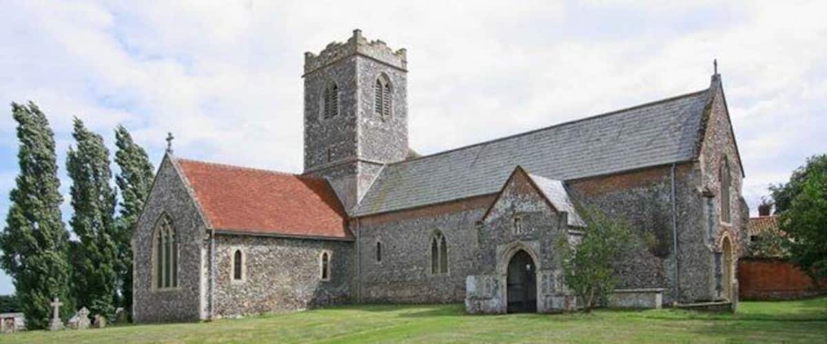 A historic church with a stone facade, a red-tiled roof, and a bell tower.