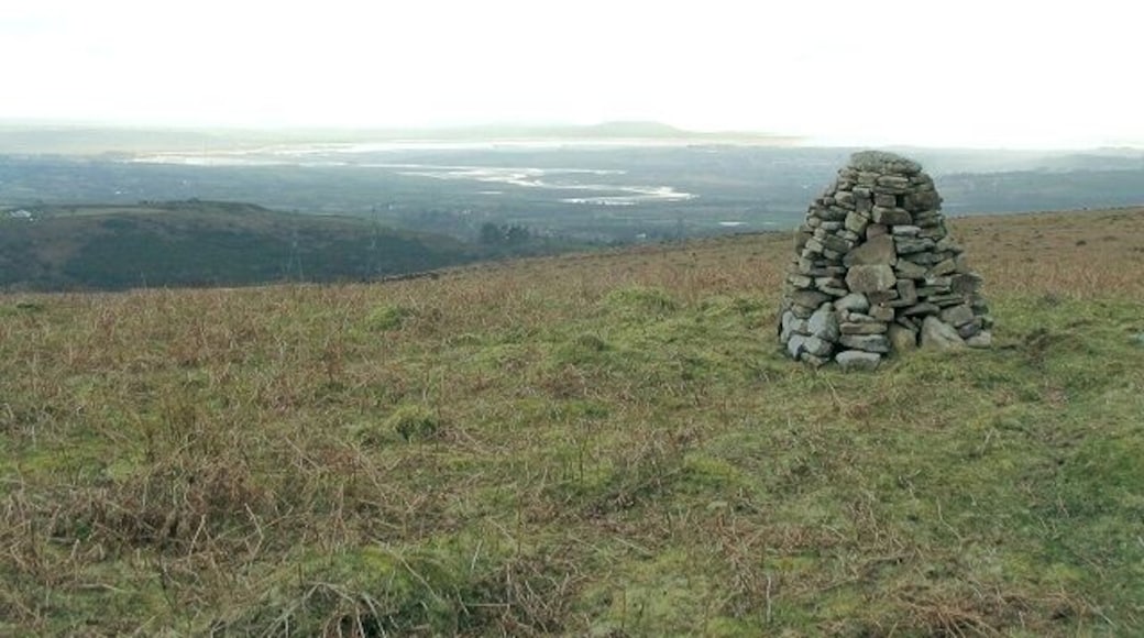 Summit cairn on Cefn Drum Just below the grassy surface of Cefn Drum is a lot of colliery spoil - ample source material for the attractive little cairn. In the distance, the Loughor winds its way out to sea, and the Gower Peninsula juts out along the horizon.