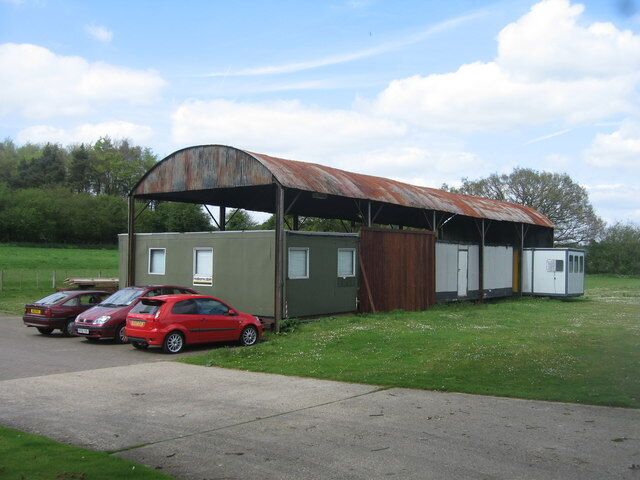 Barn sheltering some cabins Close to Dummer Garden Centre.