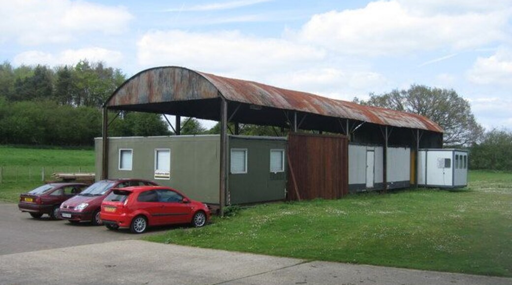 Barn sheltering some cabins Close to Dummer Garden Centre.