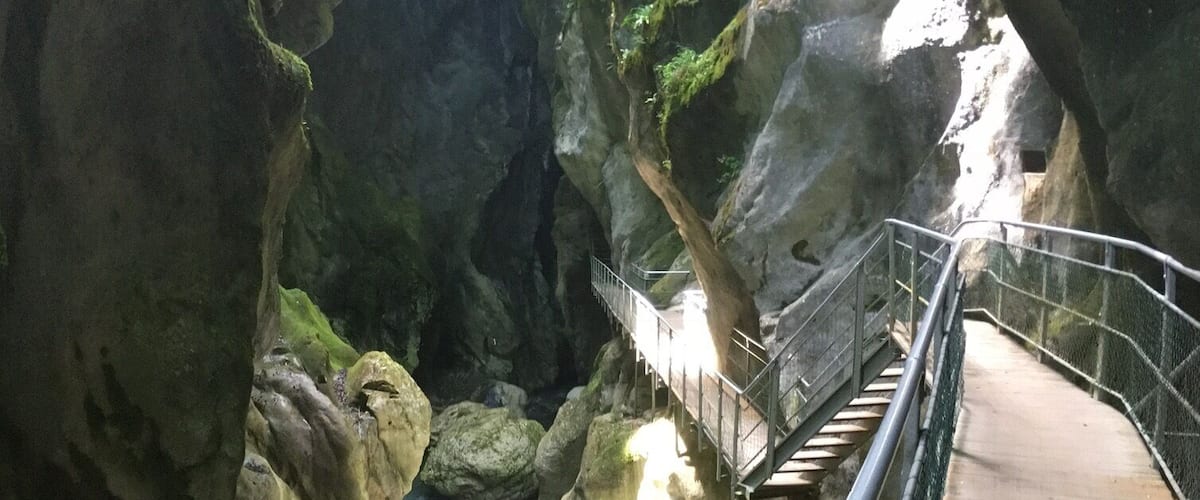 A rocky gorge with a wooden walkway and a small stream.