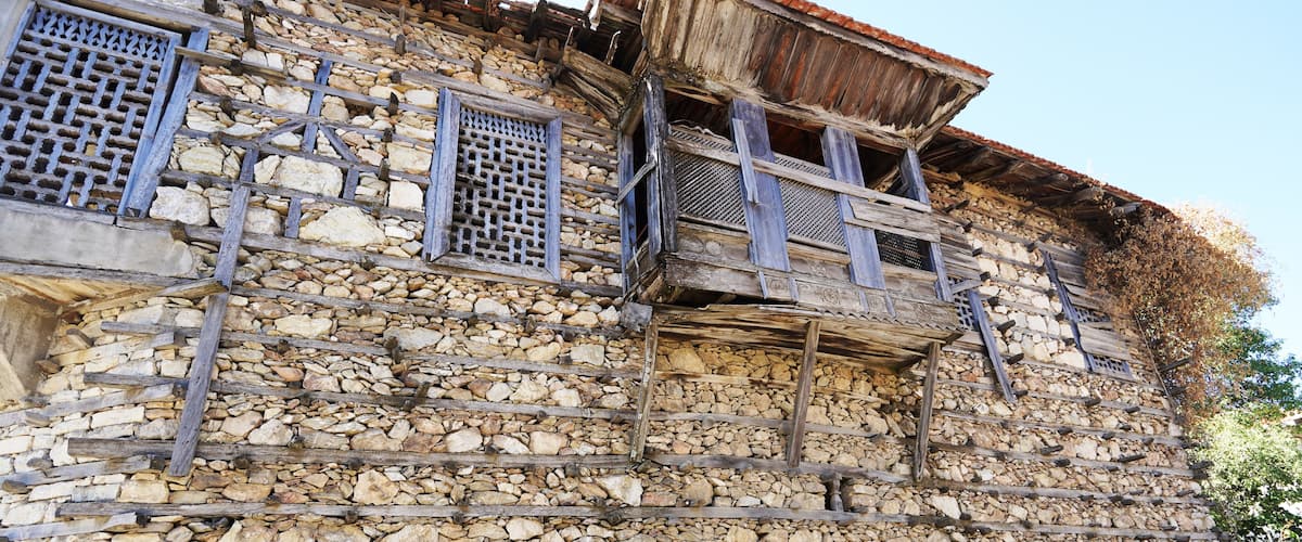 A stone building with wooden balconies and lattice windows.