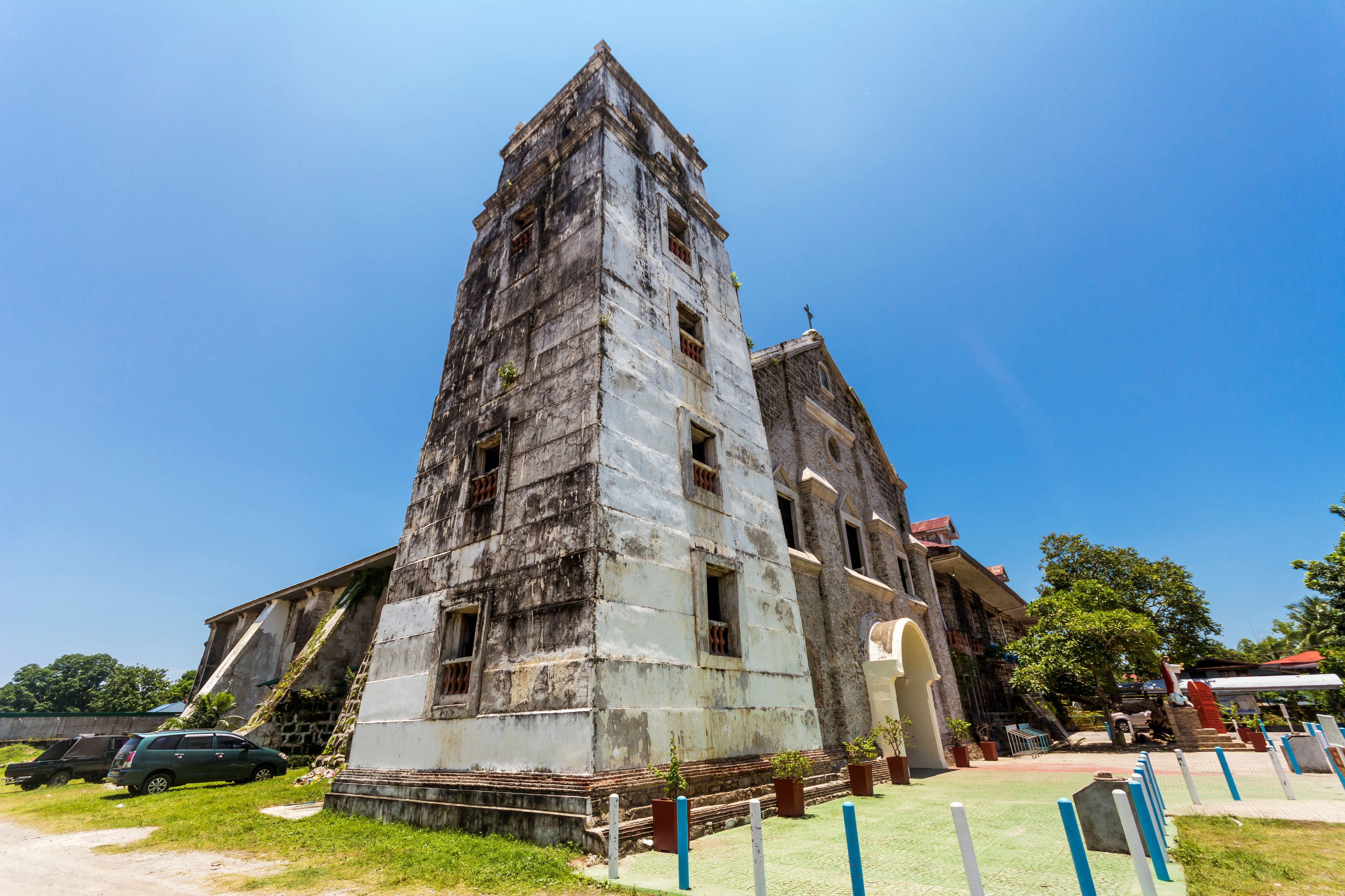 Un edificio antiguo y desgastado con un techo empinado y puntiagudo y varias ventanas.
