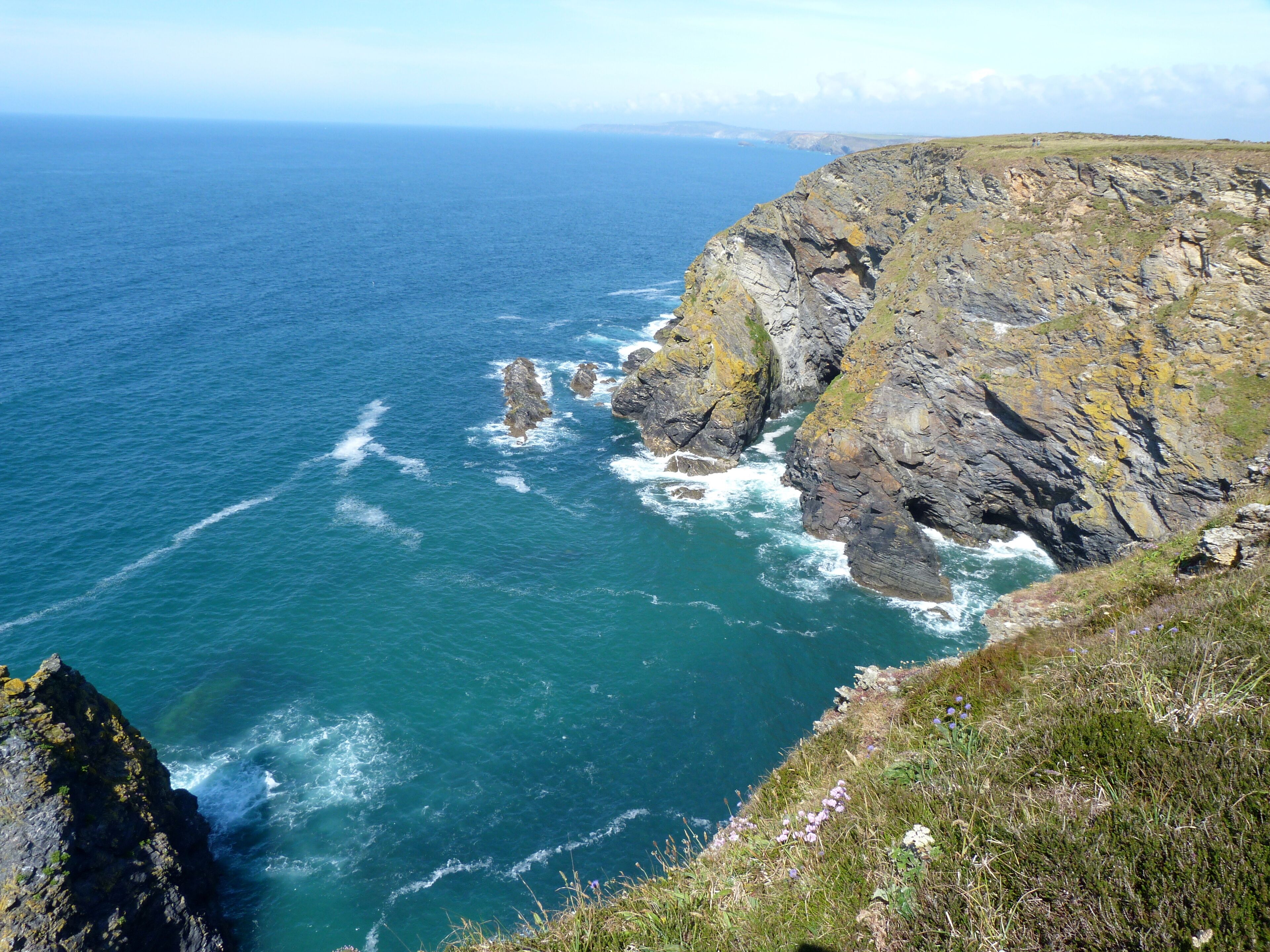 A coastal landscape with rocky cliffs and the ocean.