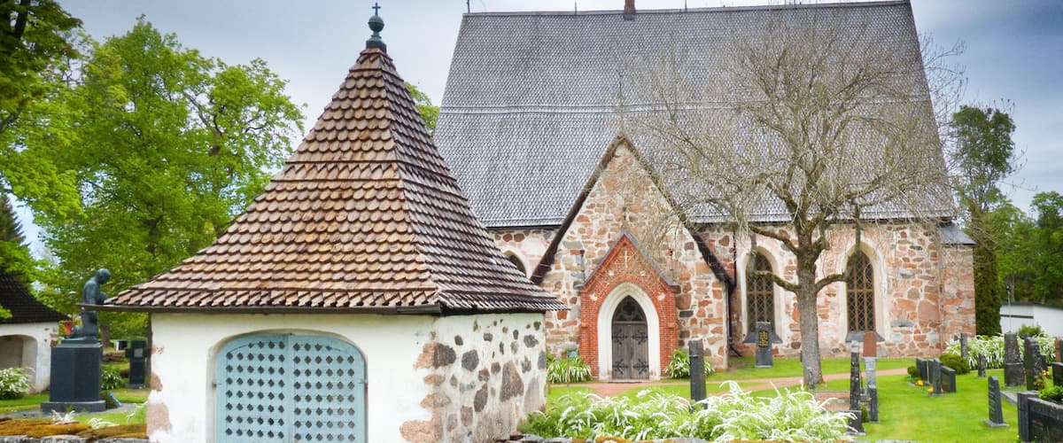 A church with a stone facade, a tiled roof, and a small bell tower.