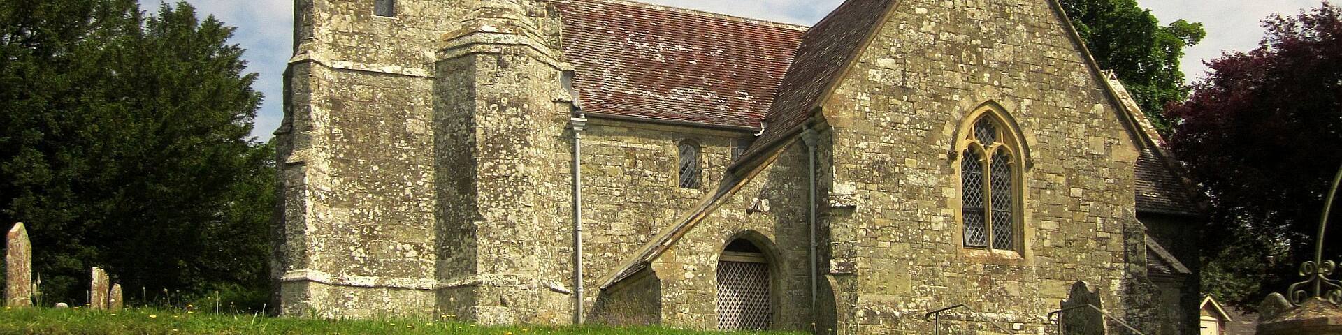 A historic stone church with a bell tower and a steeply pitched roof.
