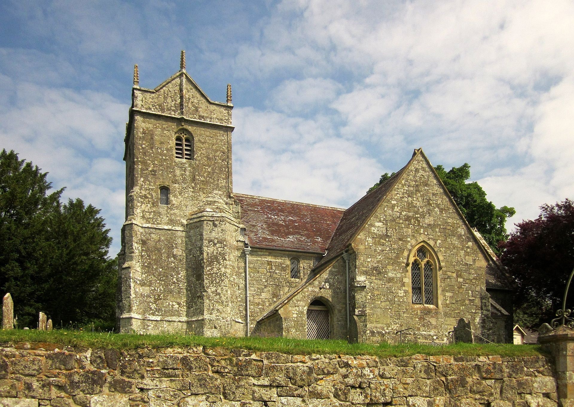 A historic stone church with a bell tower and a steeply pitched roof.