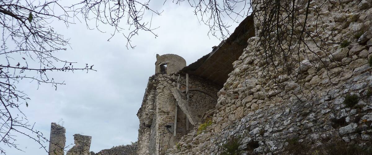Ancient stone ruins with crumbling walls and a rugged landscape.