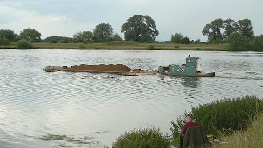 Work and leisure A contrast in water uses, with the fisherman in the foreground and the gravel barge beyond.